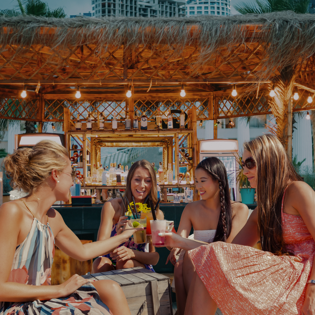 Group of women enjoying drinks with Tropic Palm's Sustainable Agave Company Straws